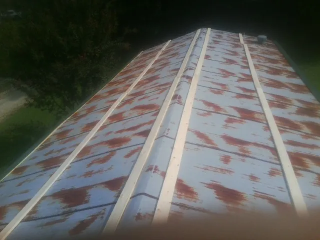 Rusted metal roof panels with new wood purlins before replacement — Storm Damage Roof Repair in Rosamond by Roofing Brothers